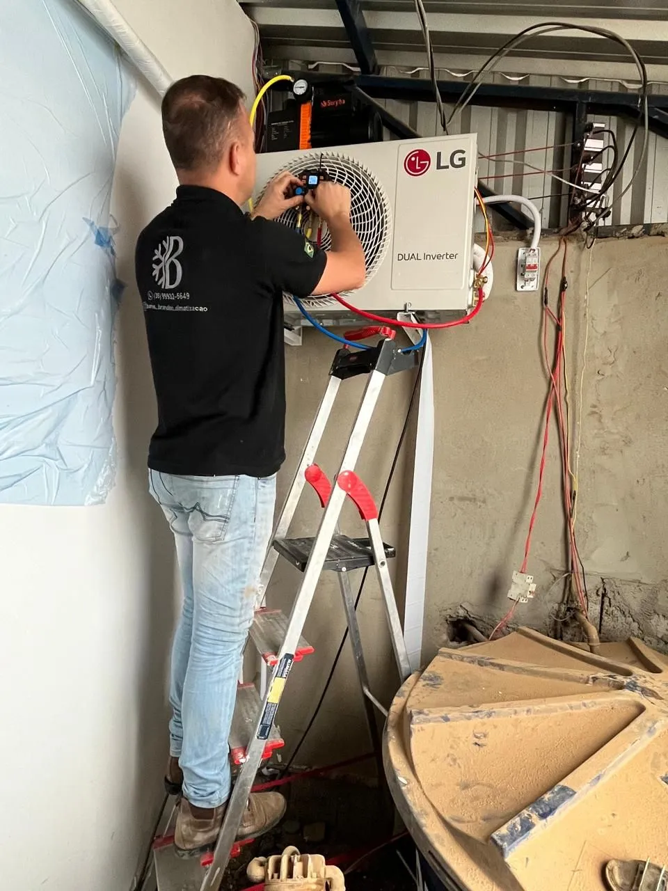 Técnico da Barros & Brandino em uma escada fazendo medições na condensadora LG Dual Inverter